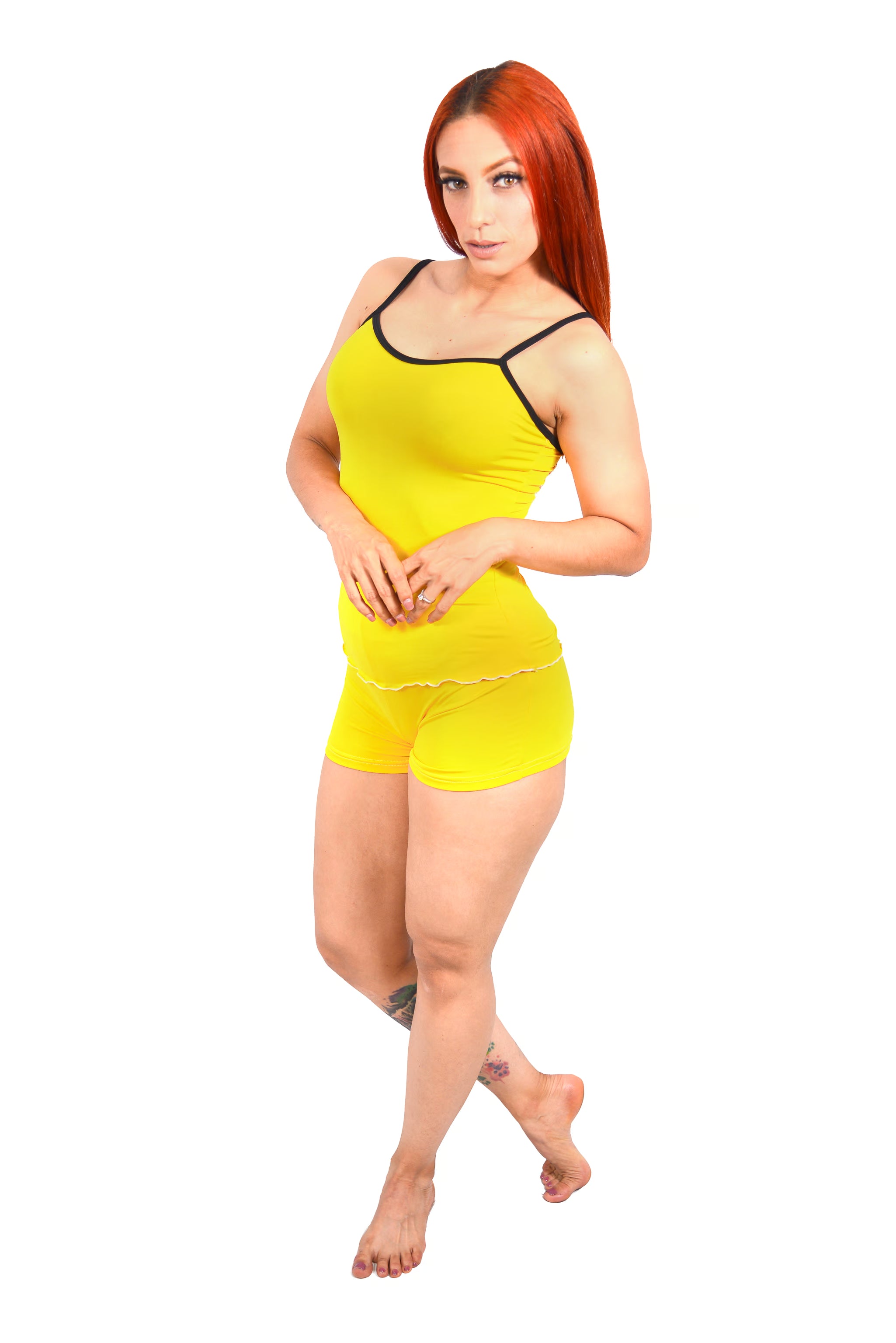 Woman wearing a yellow cami  top and shorts set on a white background