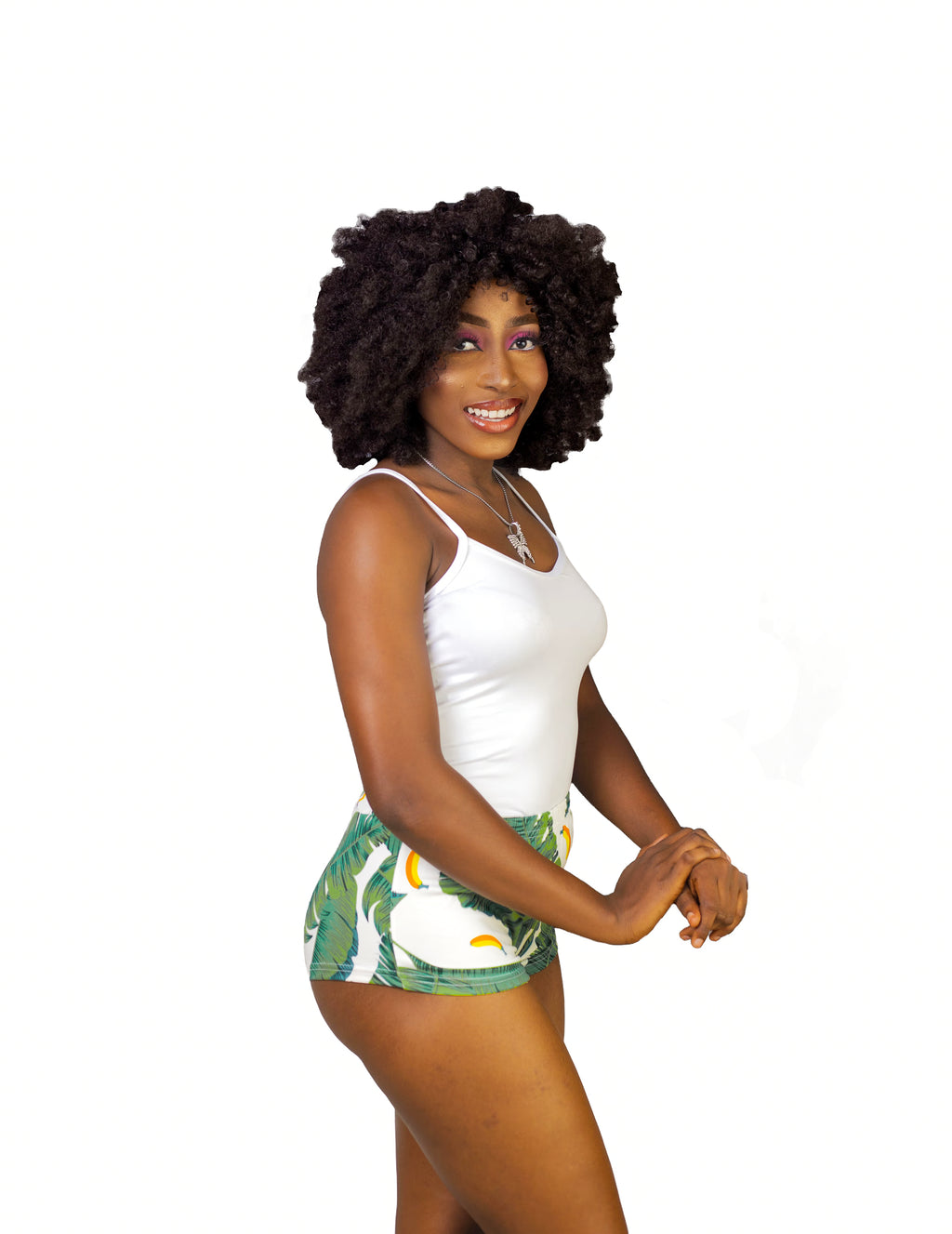 Woman wearing a white tank top and green leaf shorts sleepwear set on a white background