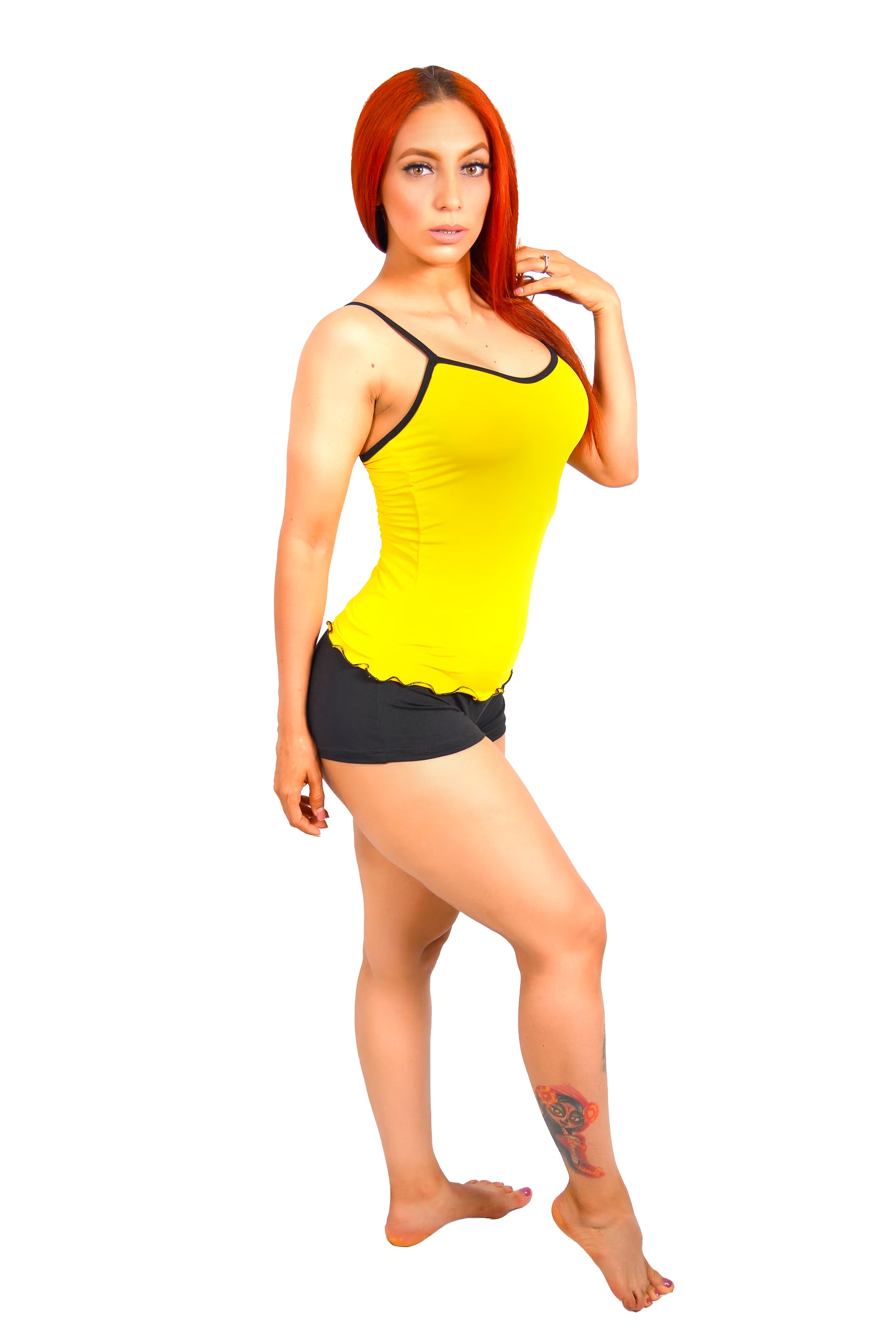 Woman wearing a yellow tank top and black shorts on a white background