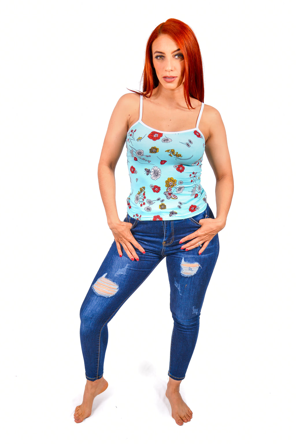 Woman wearing a Camisole floral top and blue jeans on a white background