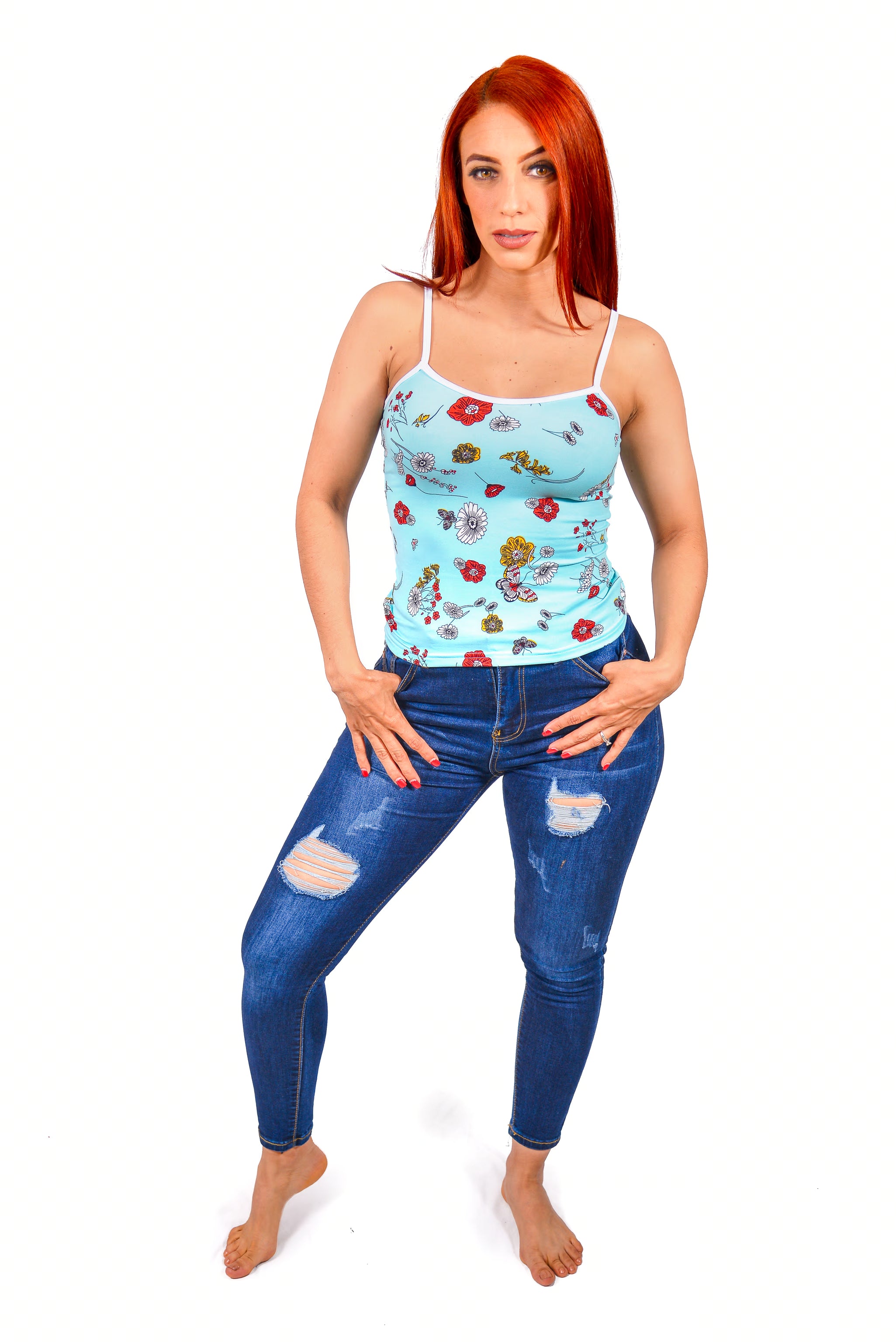 Woman wearing a Camisole floral top and blue jeans on a white background