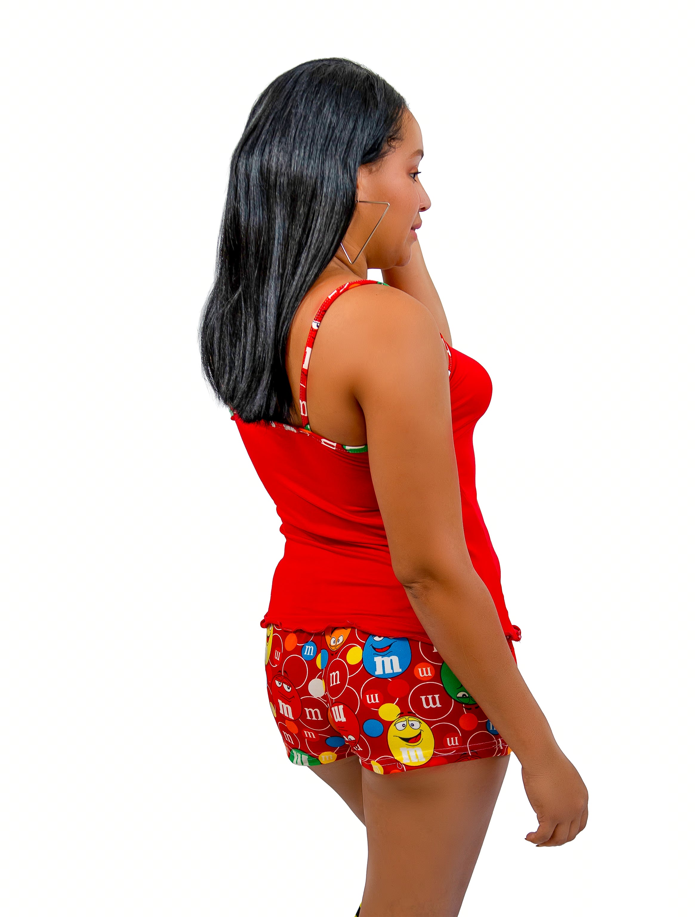Woman wearing a red top and colorful shorts with candy design on a white background