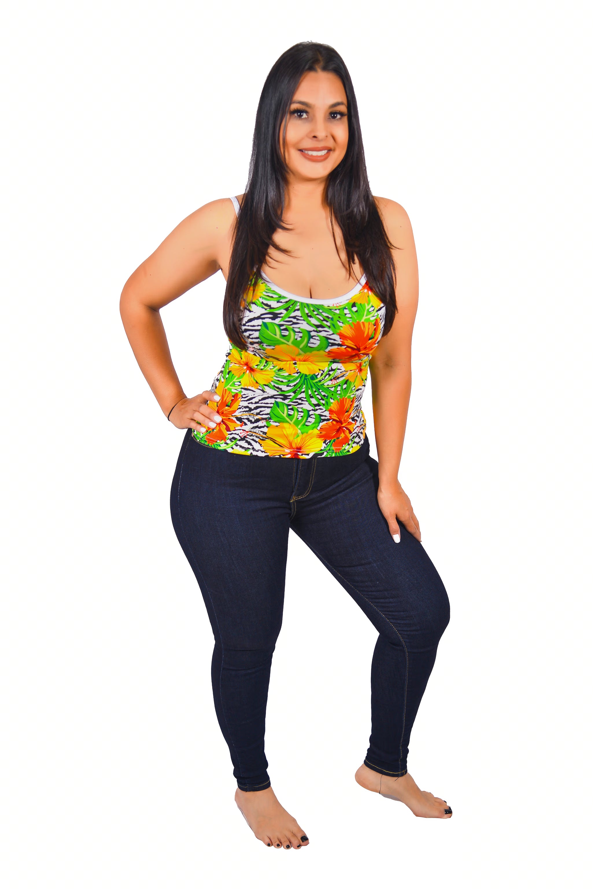 Woman wearing a colorful Cami top with floral and zebra pattern with jeans on a white background