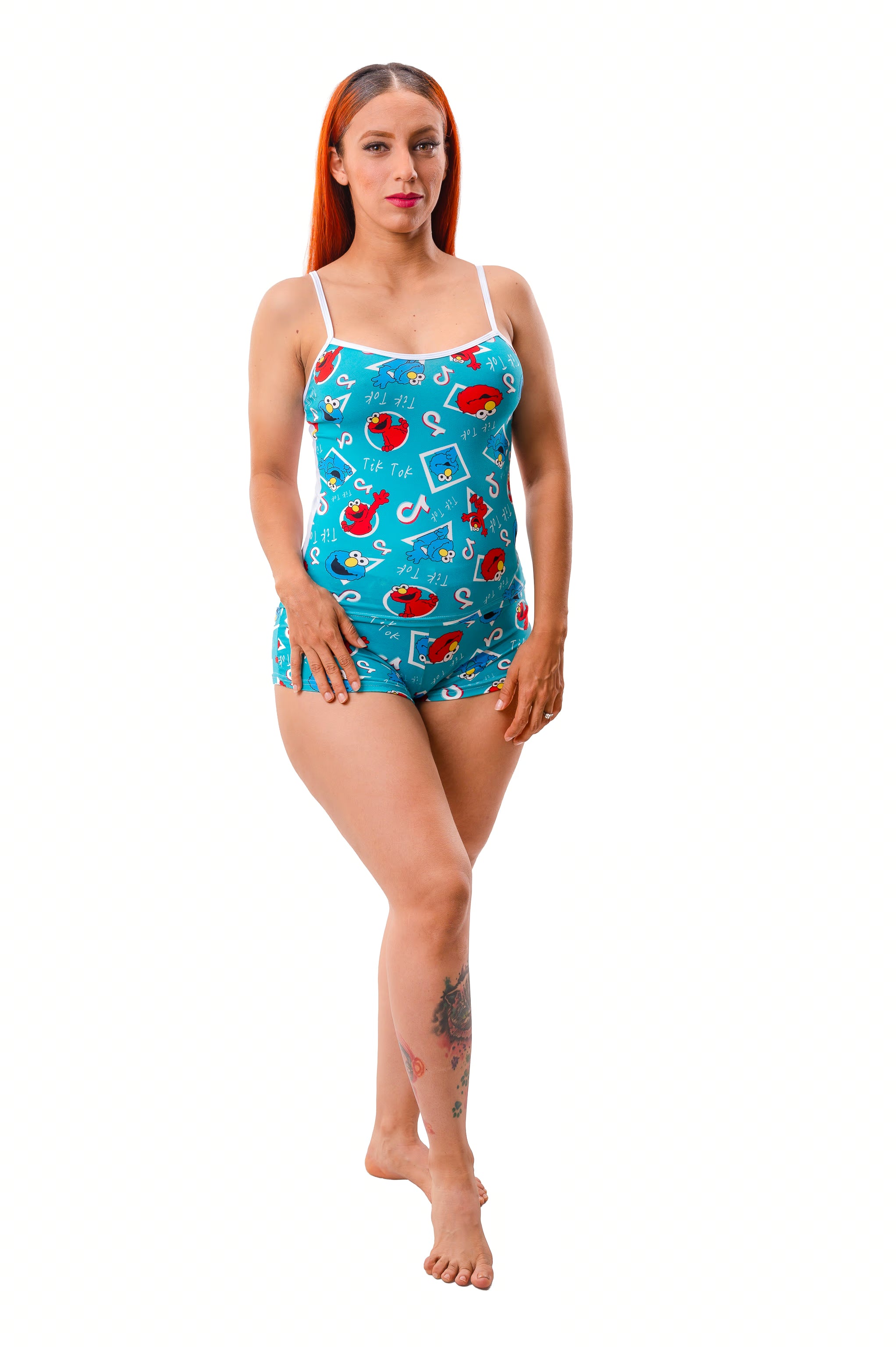 Woman wearing a blue cami pajama set with a colorful pattern on a white background