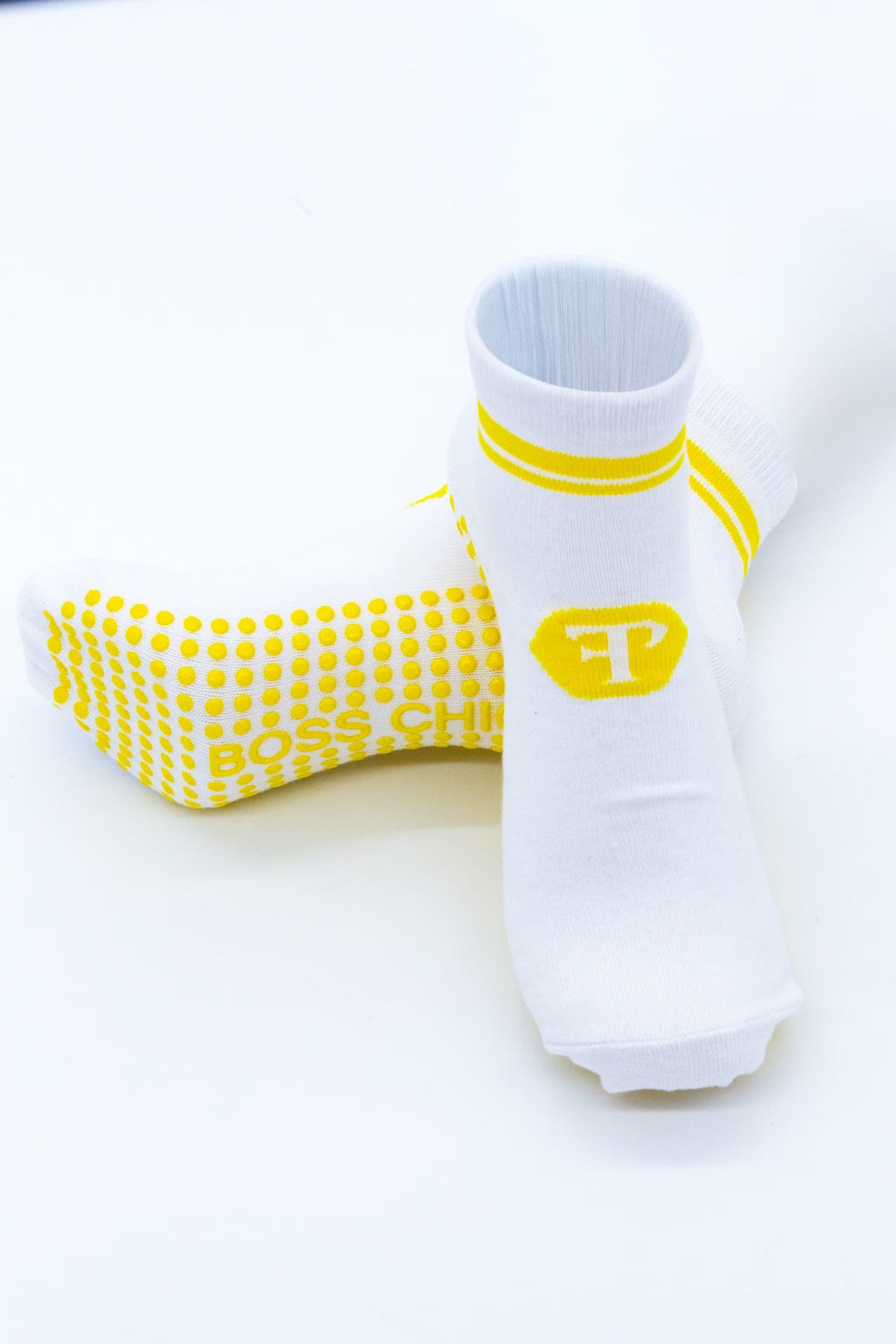 White socks with yellow (Finesse Popular Logo) Logo and stripes on white background