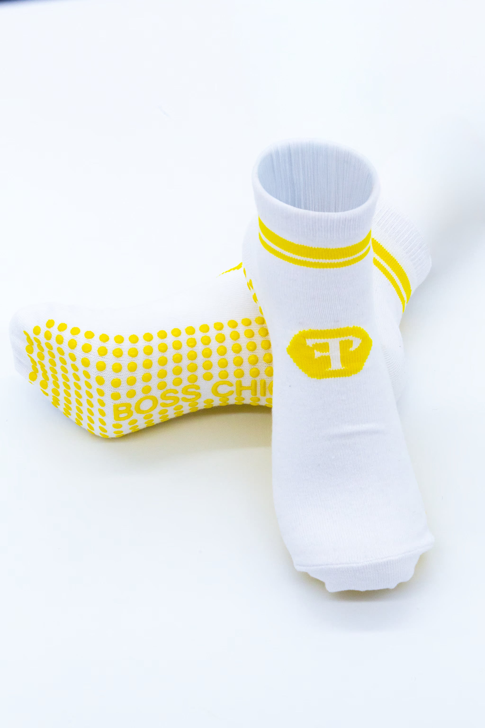 White socks with yellow (Finesse Popular Logo) Logo and stripes on white background