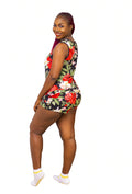 Woman wearing a black floral 2-piece tank and shorts pajama set on a white background