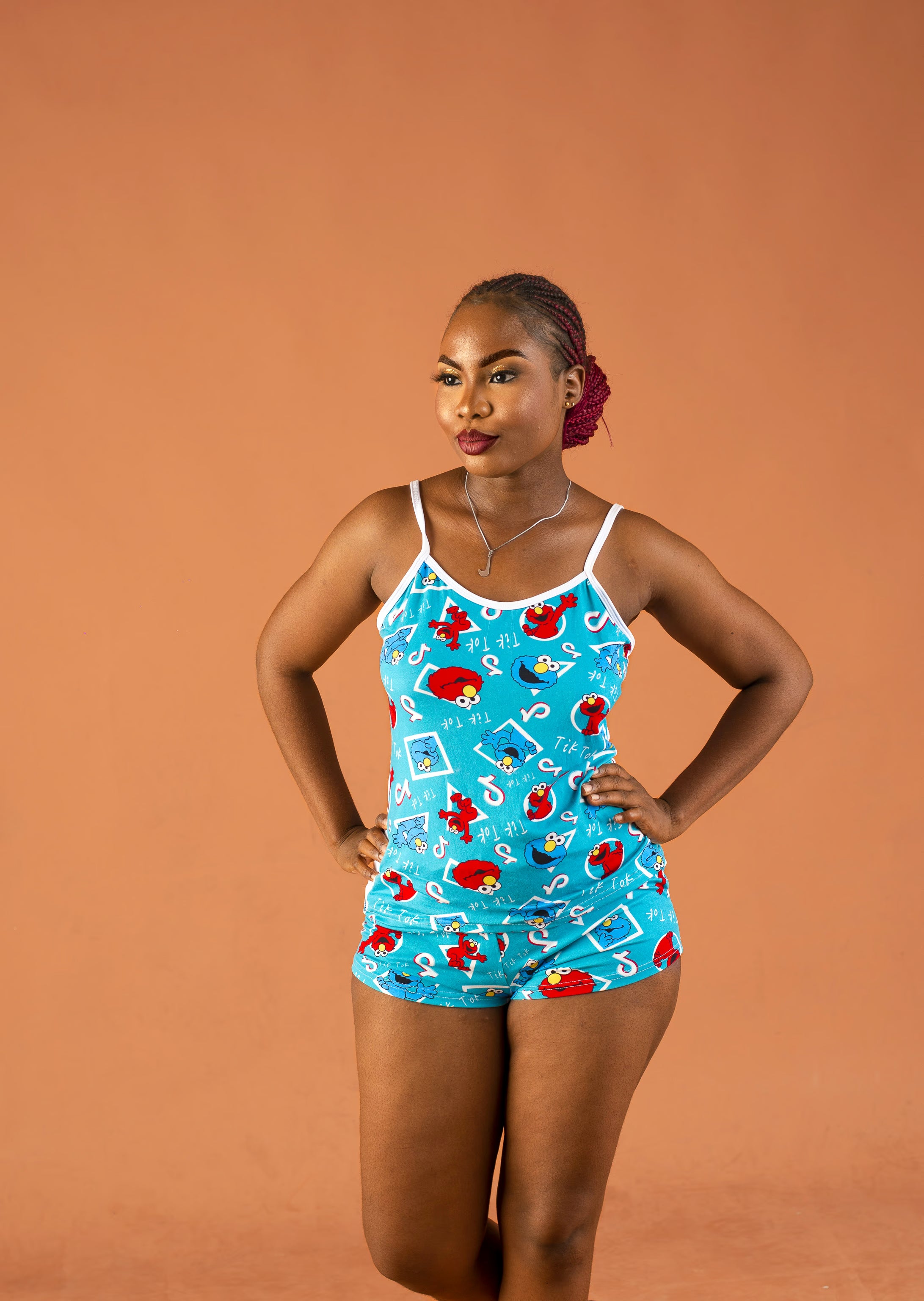 Woman wearing a blue patterned sleepwear against an orange background