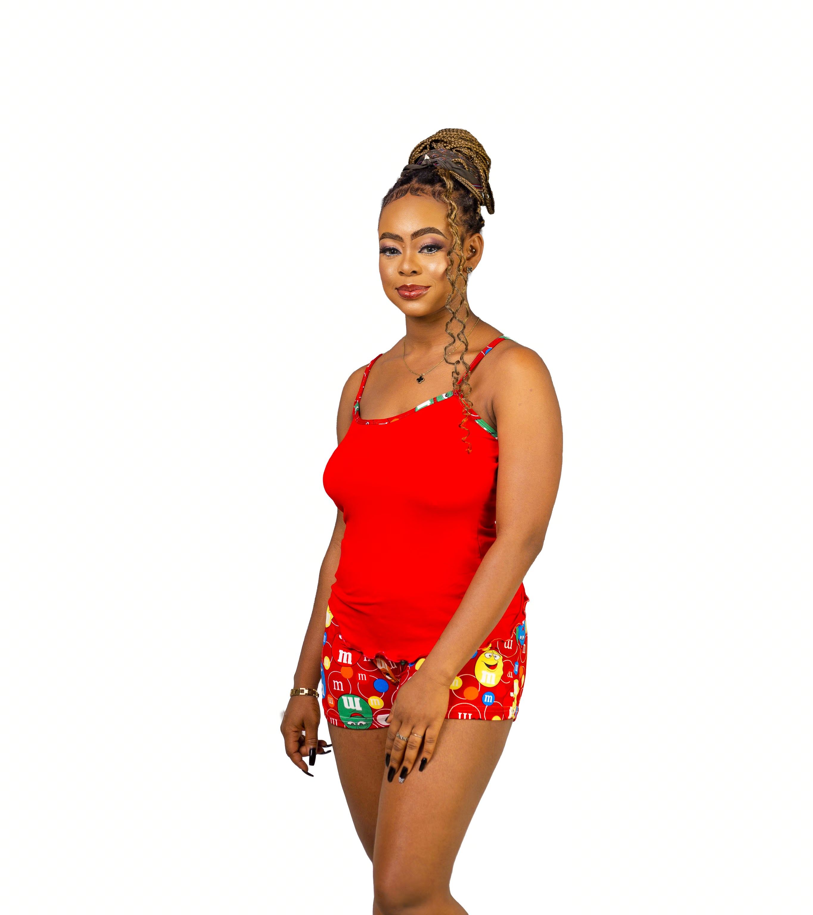 Woman wearing a red Cami top and colorful candy patterned shorts on a white background