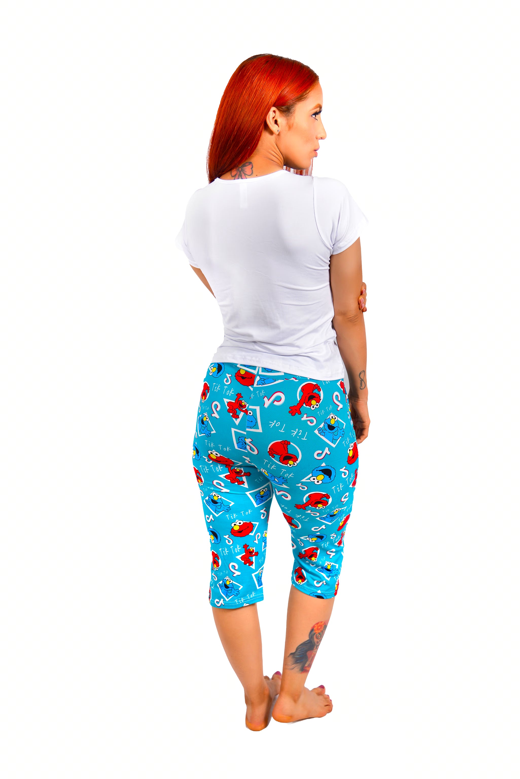 Lady wearing a solid white back panel design and full retro character print on pants on a white background