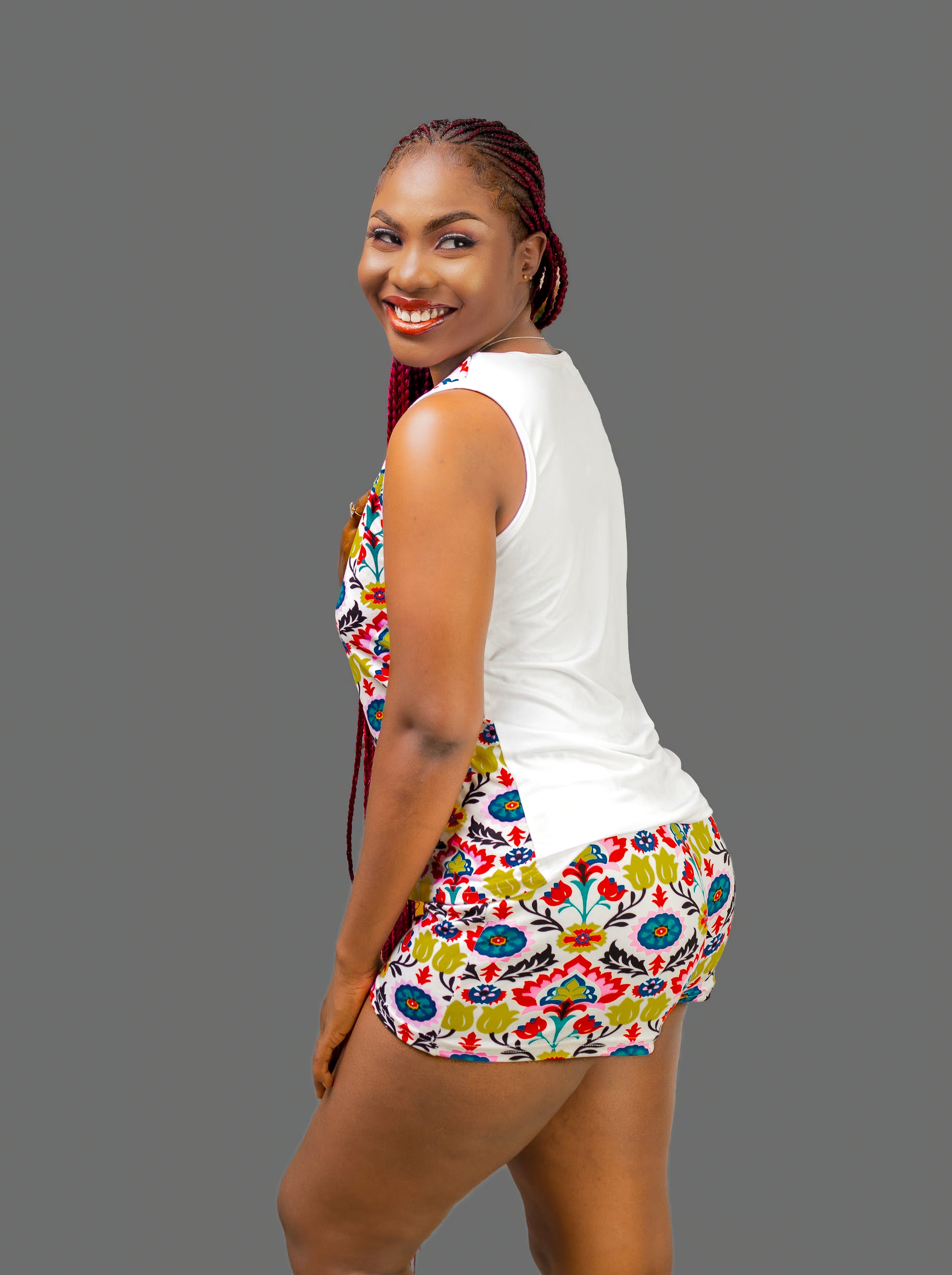 Woman wearing a colorful latin art pajama set with tank top with a white back on a gray background