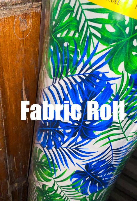 Fabric roll with blue and green leaf pattern on a wooden surface