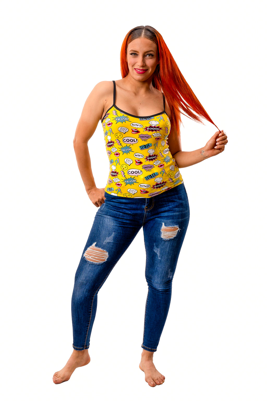 Woman wearing yellow pop art camisole with comic-style captions styled with jeans on white background