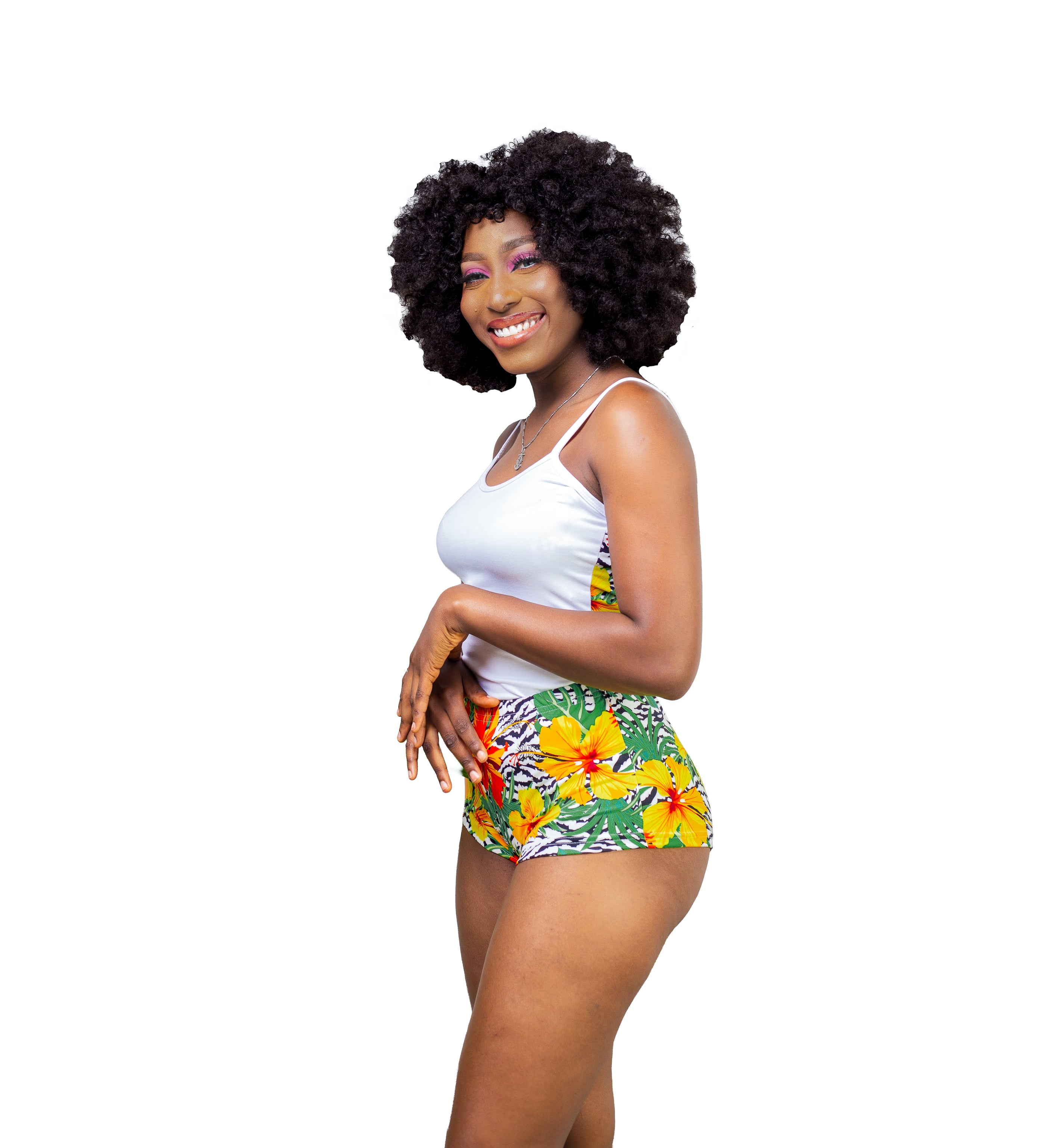 Carribean Woman wearing a white Cami top and tropical print shorts on a white background