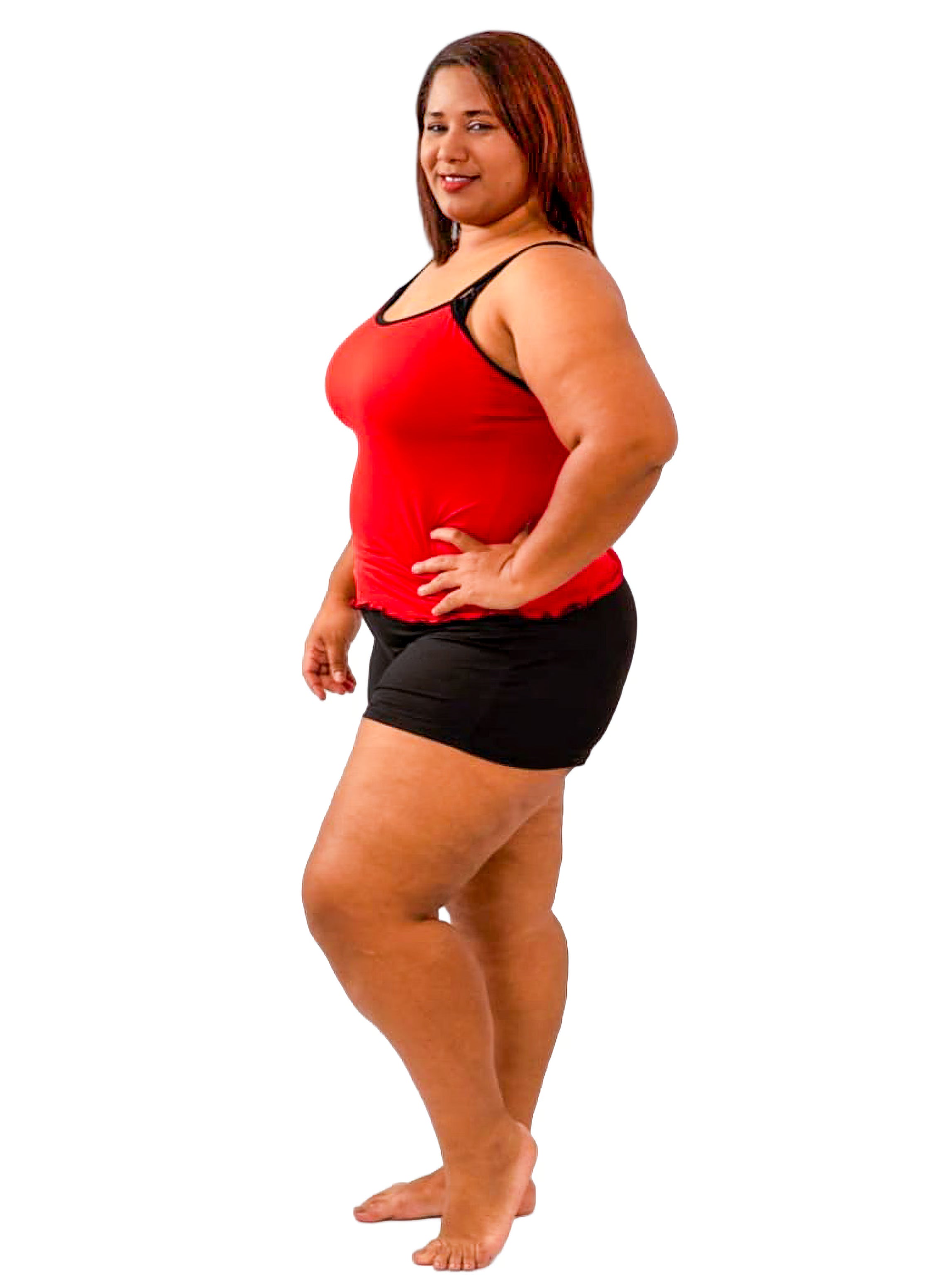 Woman wearing a red cami top and black pajama shorts on a white background