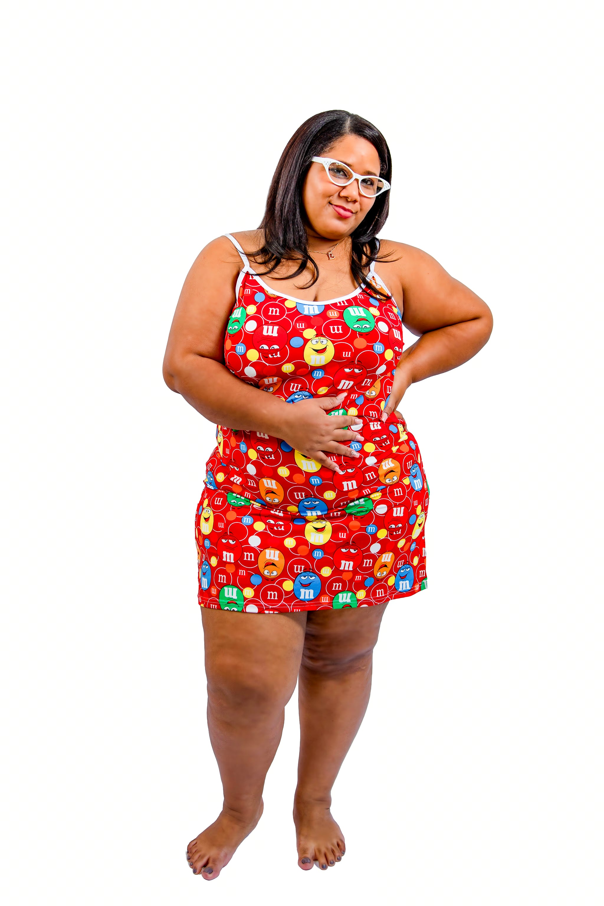 Woman wearing a red pajama set with colorful candy-themed design on a white background